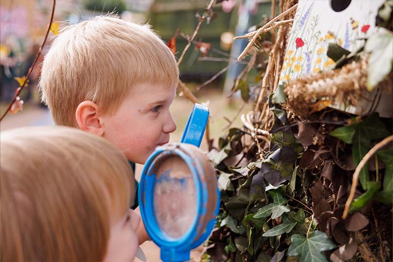 students outside looking through maginfying glass